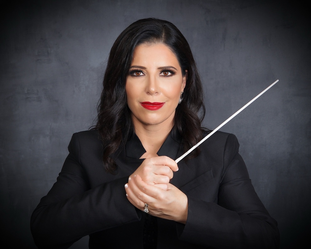 Woman in black holding conductor's baton.