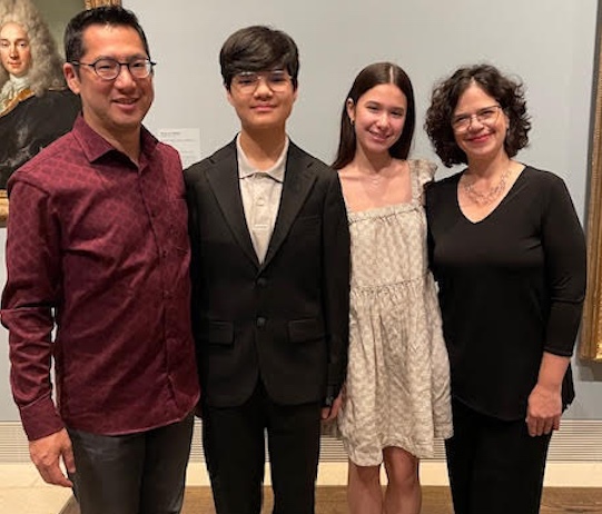 Two parents with teen children dressed for special event.